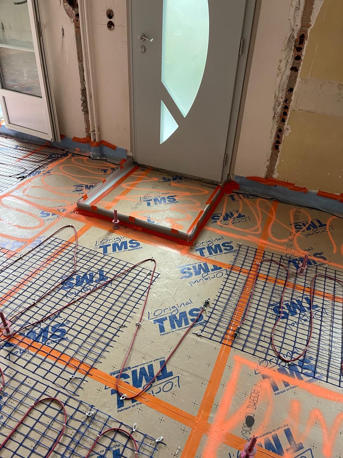 Une pièce avec une porte et beaucoup de fils sur le sol.