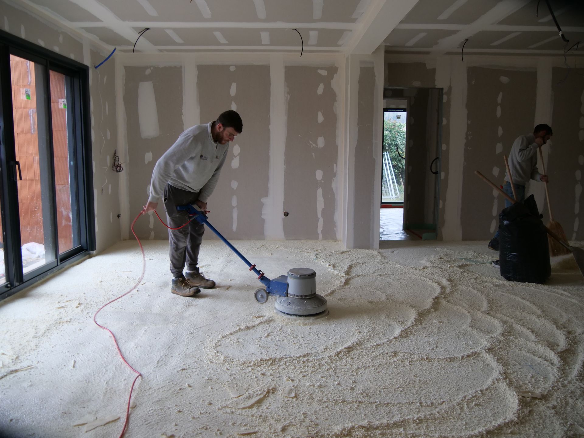 Un homme nettoie le sol avec un aspirateur