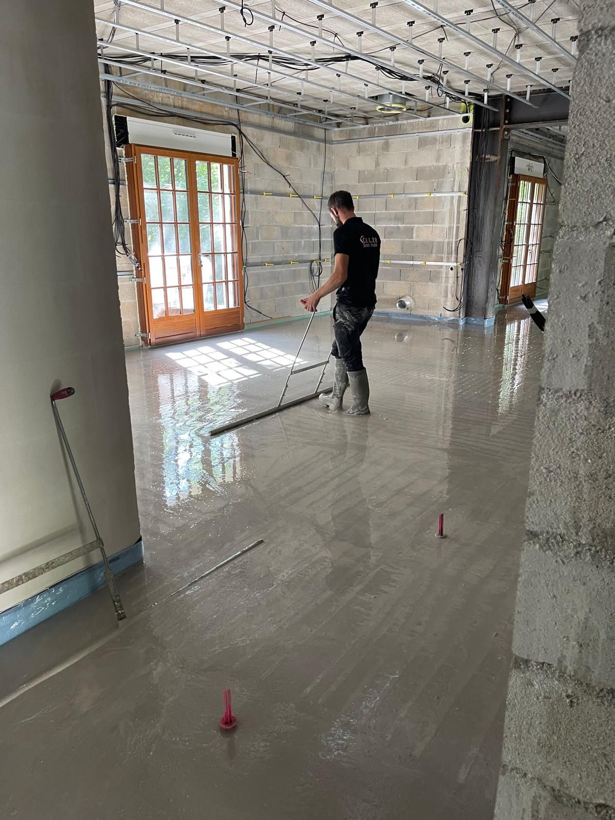 Une pièce avec beaucoup de fenêtres et un sol en béton.