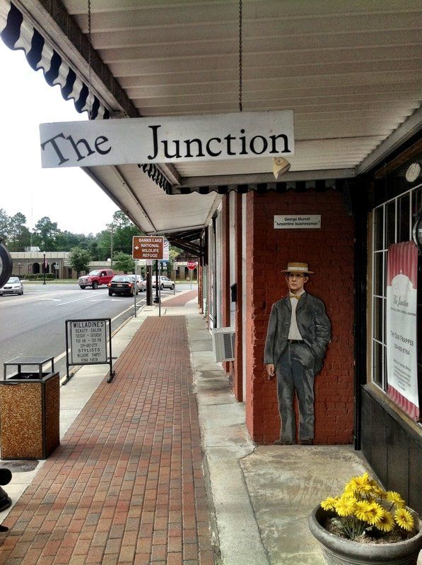 A sign for the junction hangs from the roof of a building