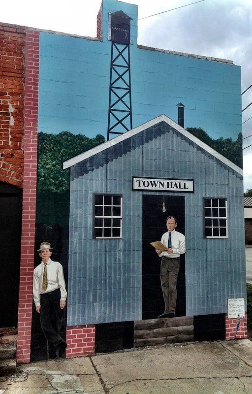 A mural of two men in front of a town hall