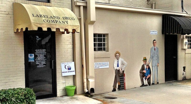 A building with a yellow awning that says lakeland drug company