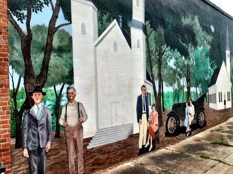 A mural of a family standing in front of a church