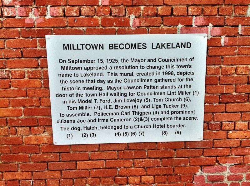 A sign on a brick wall that says milltown becomes lakeland