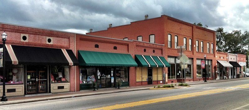 A row of stores with green awnings on a cloudy day