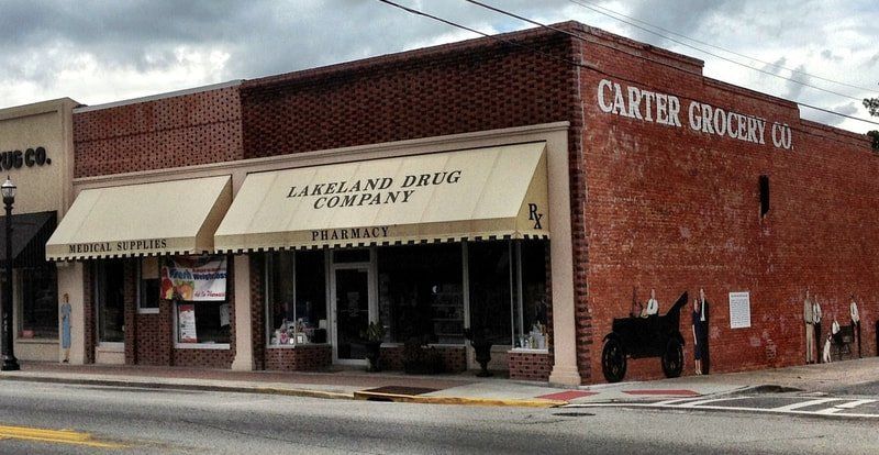 A brick building with a white awning that says carter grocery co.