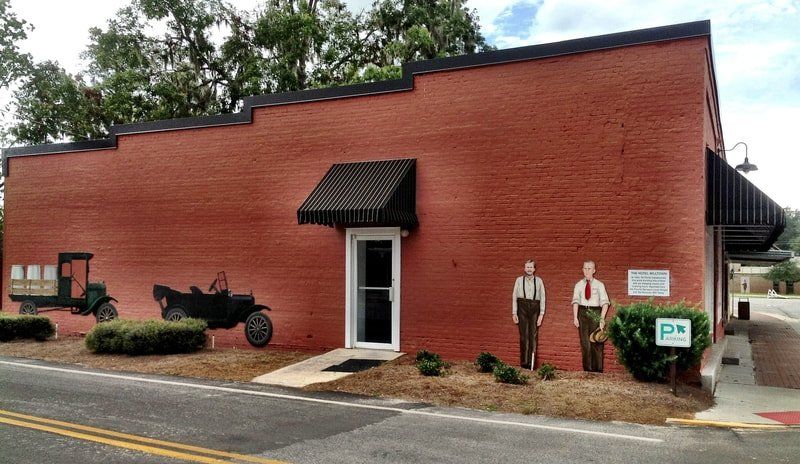 A red brick building with a painting of a truck and two men on the side