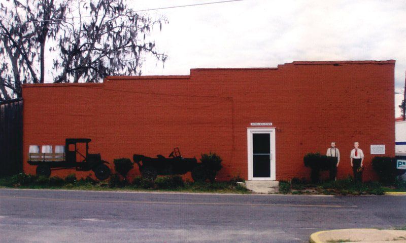 A red brick building with a tractor painted on the side