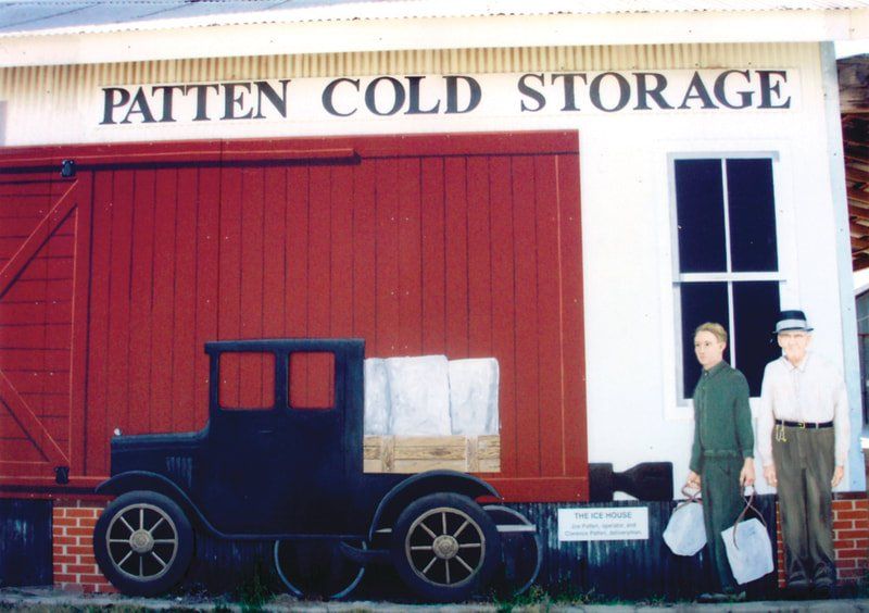 A painting on the side of a building that says patten cold storage