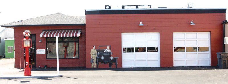 A red building with a gas pump in front of it