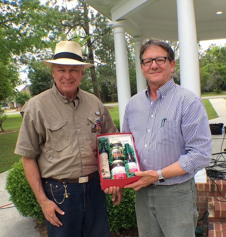Two men standing next to each other holding a red box