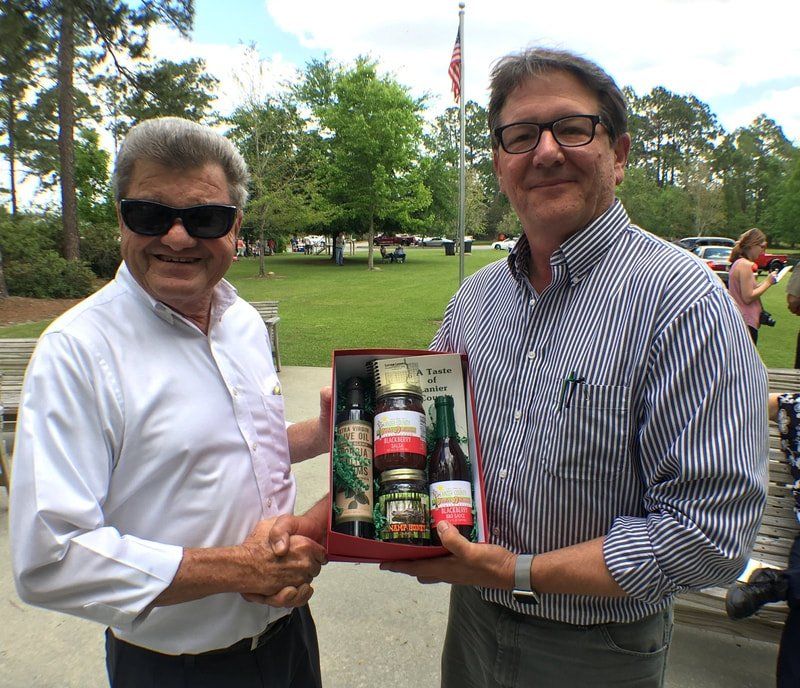 Two men standing next to each other holding a box of food