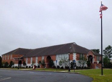 A large brick building with an american flag in front of it