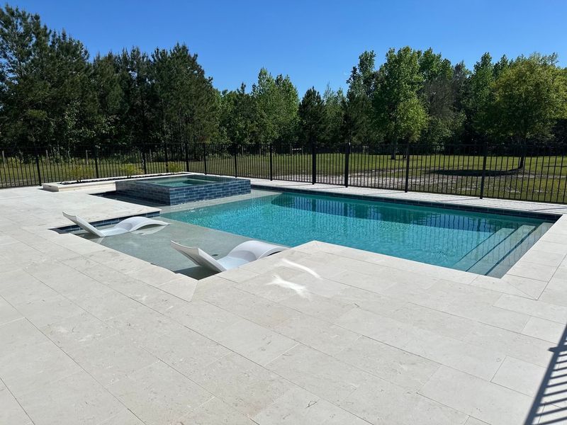 Newly constructed concrete swimming pool with plumbing fixtures, outdoors.