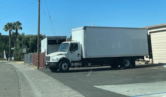A white truck is parked on the side of the road.