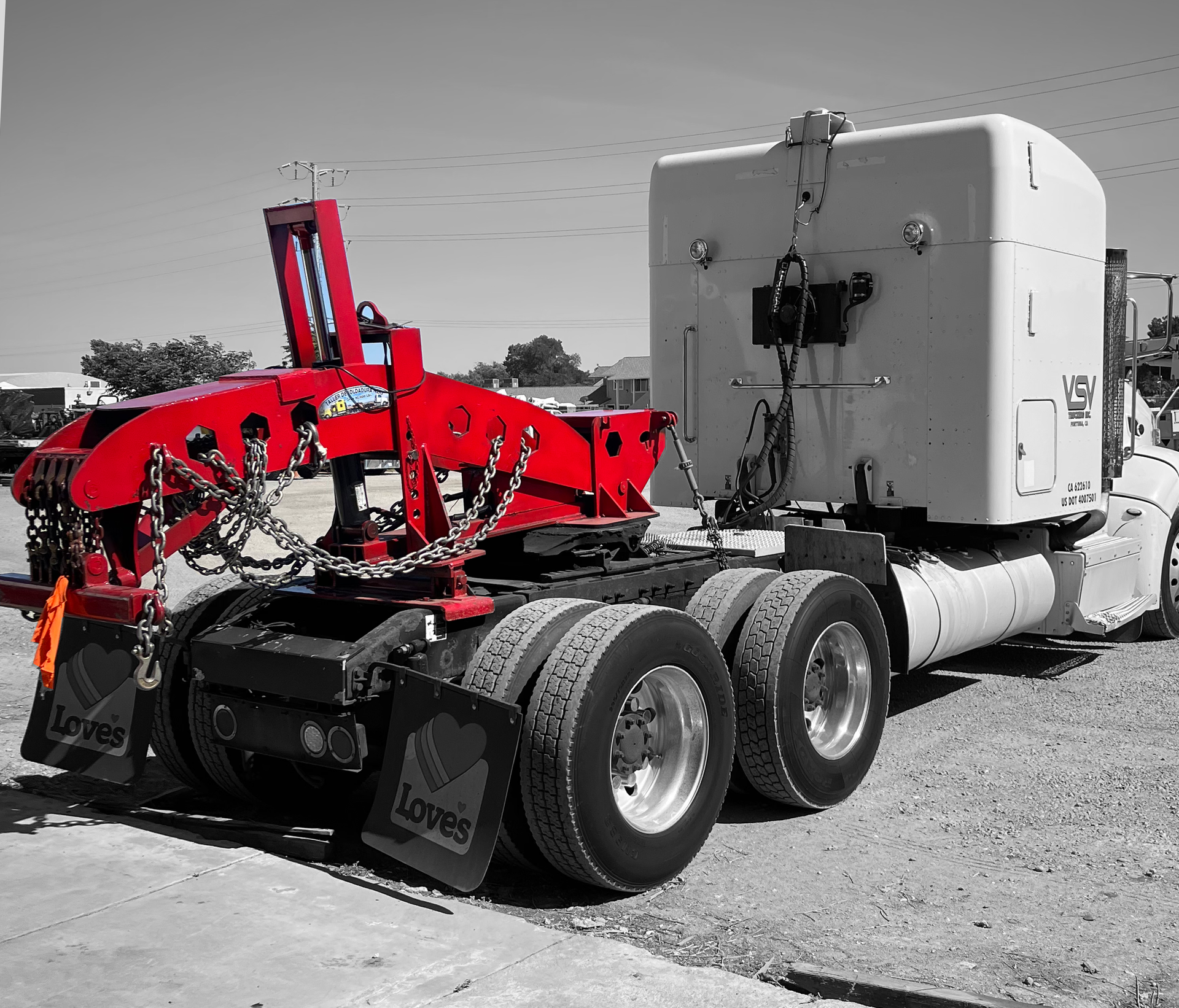A white semi truck with a red crane attached to the back
