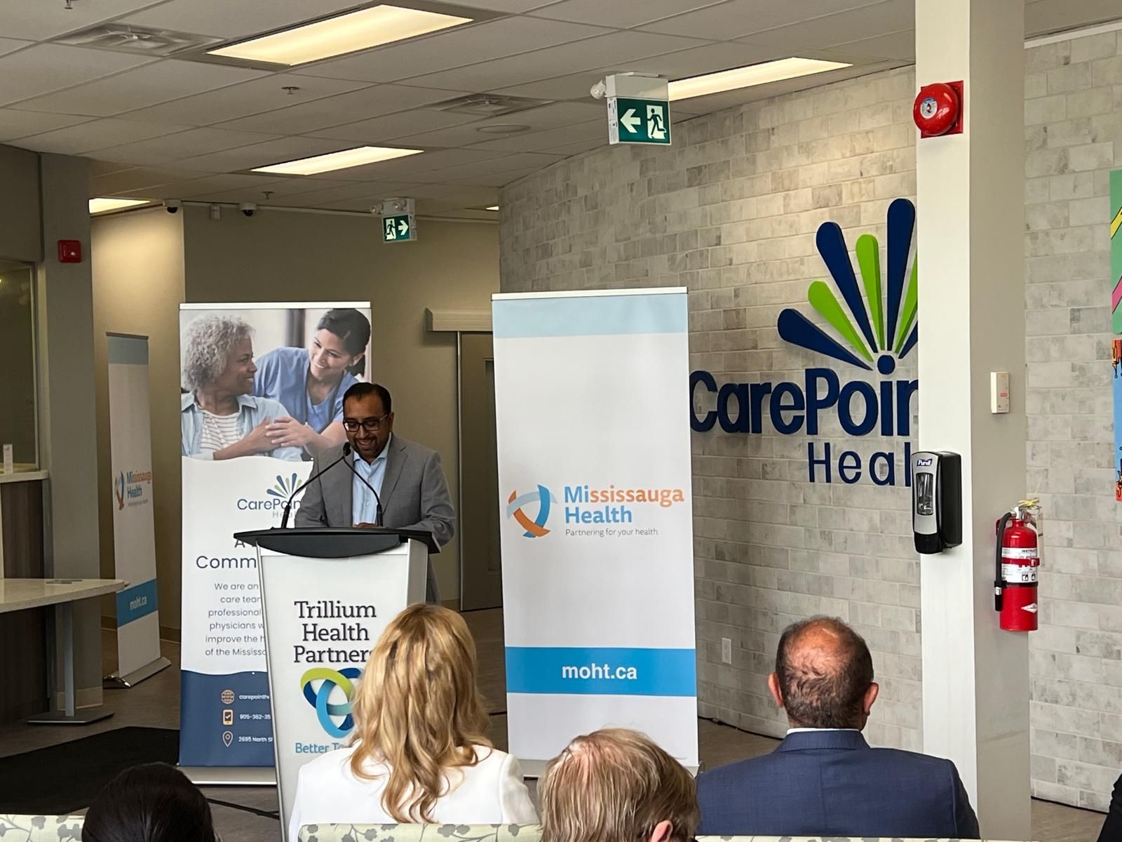 A man is giving a speech at a podium in front of a group of people.