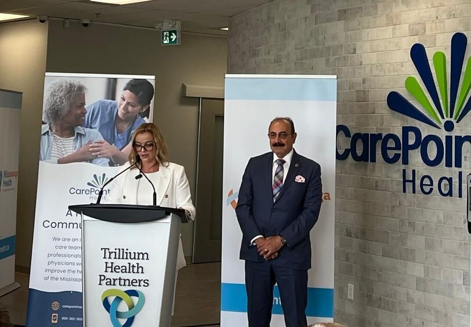 A man and a woman are standing in front of a podium that says trillium health partners