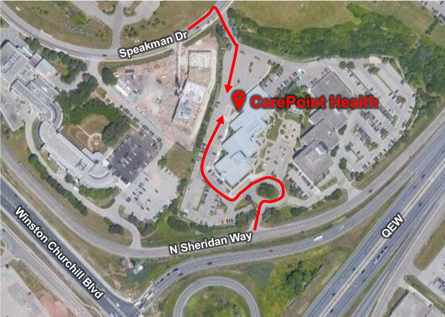 An aerial view of a hospital with a red arrow pointing to it