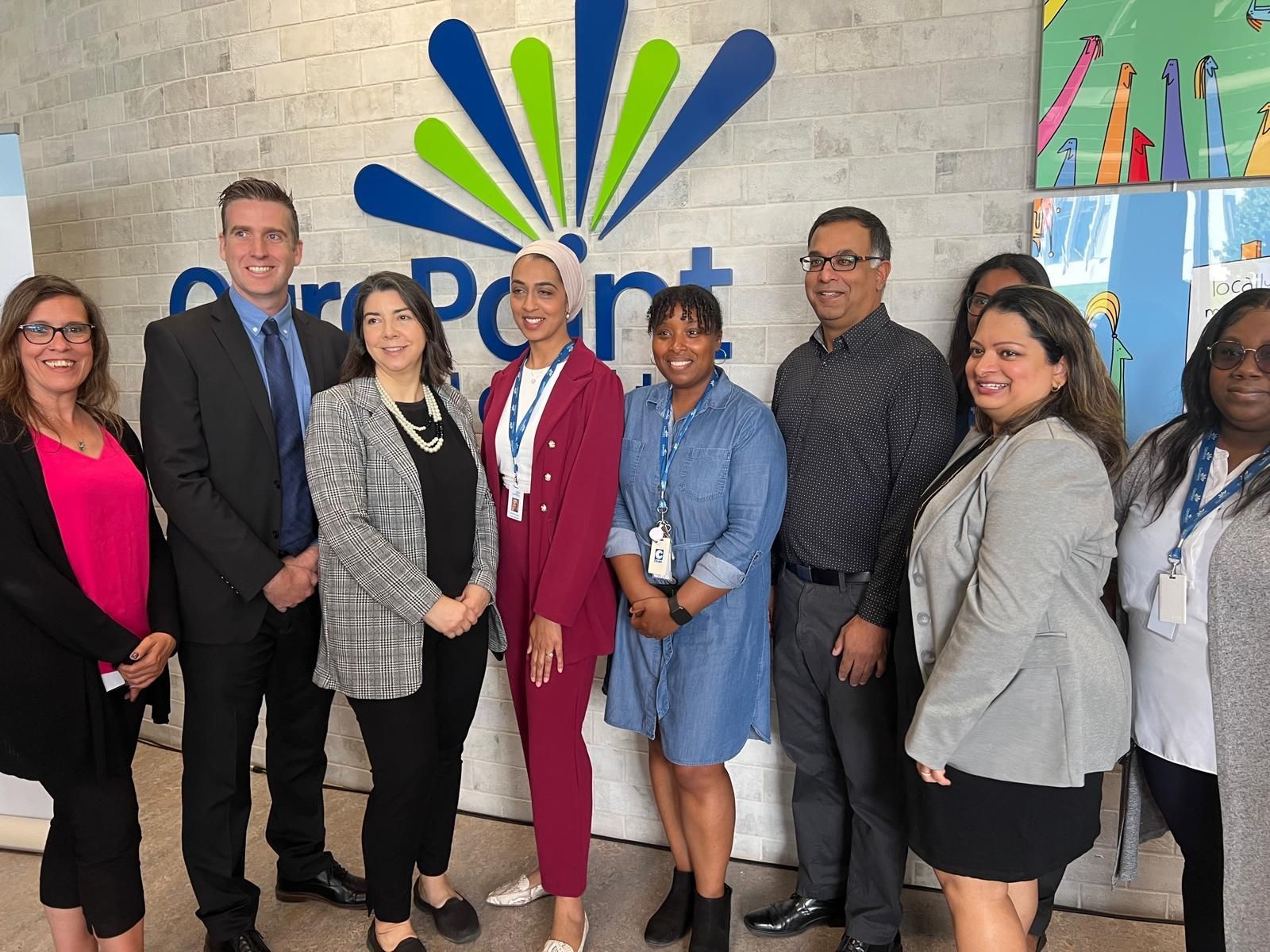 A group of people are posing for a picture in front of a sign.