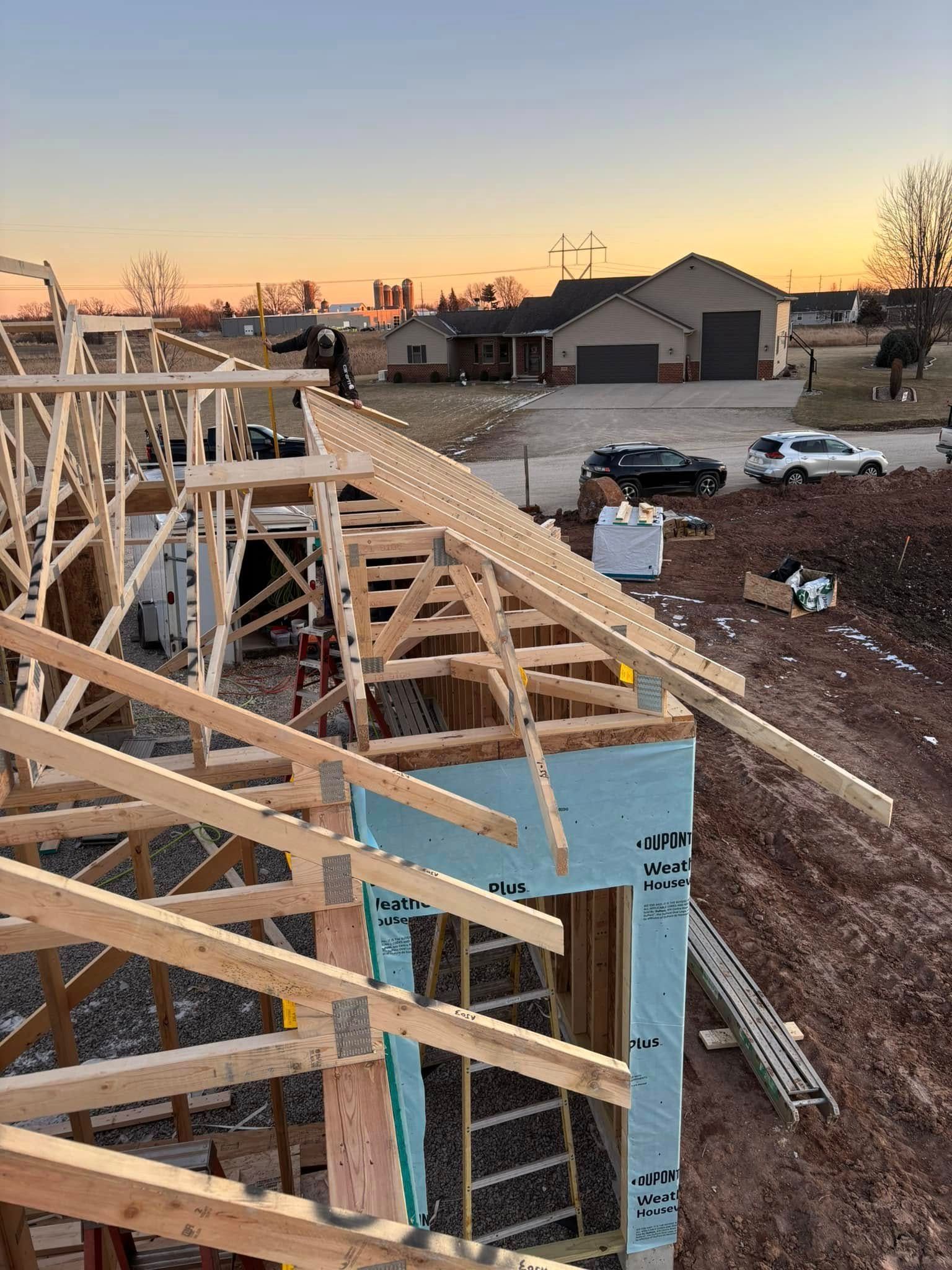 Construction site with wooden frame of a building at sunset.