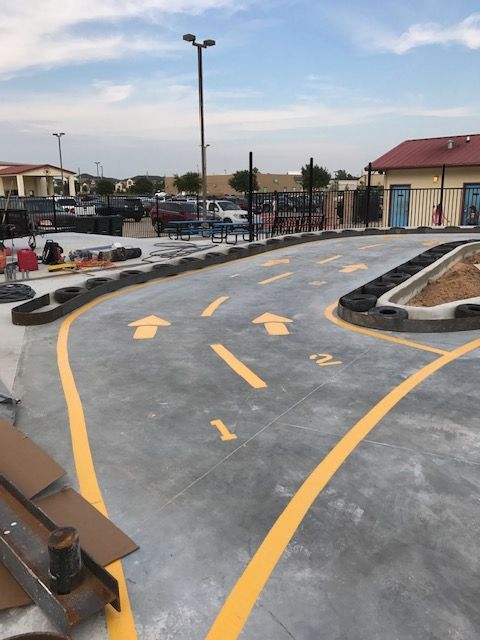 A paved track with painted yellow arrows and lane numbers 