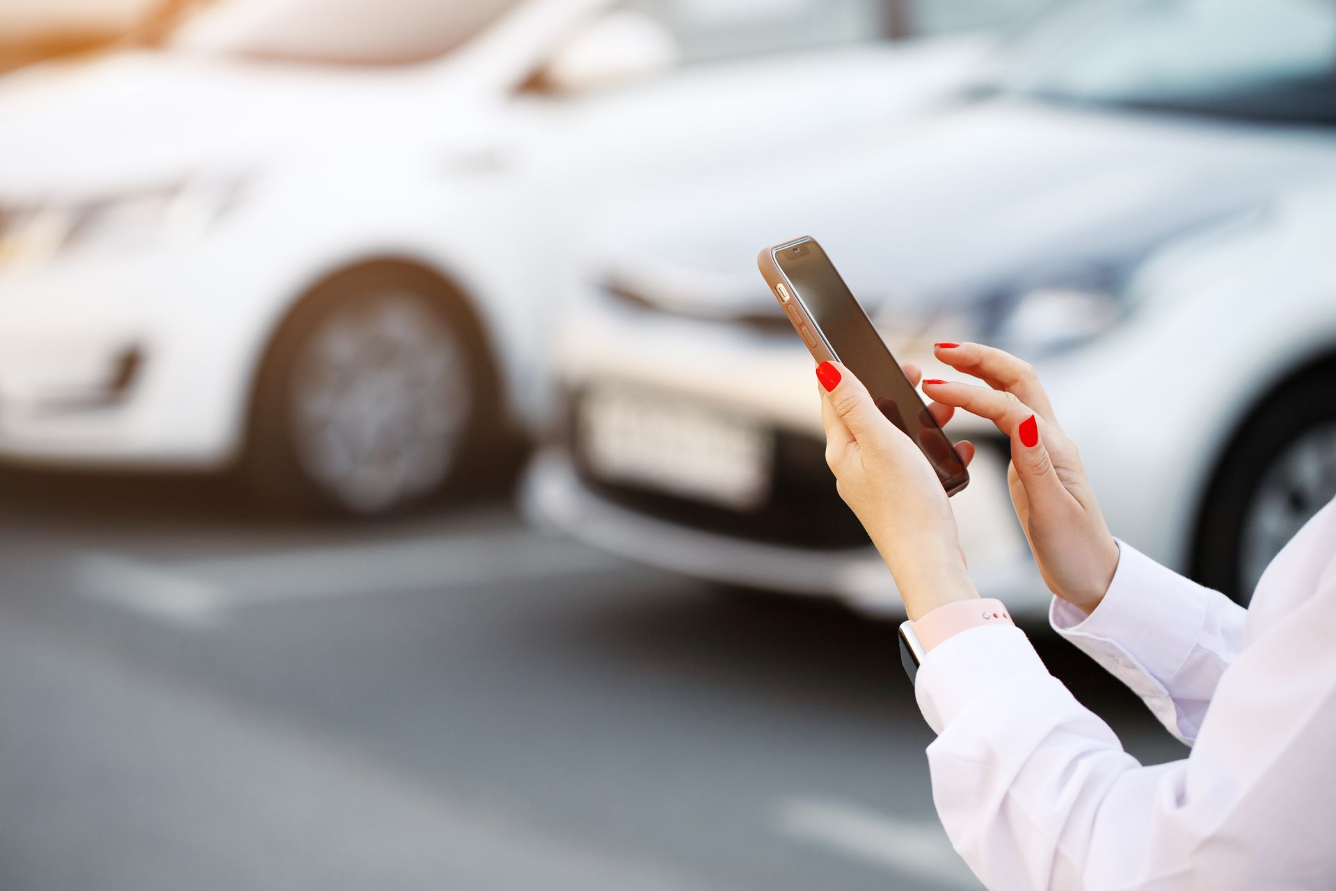 woman using a phone near a vehicle
