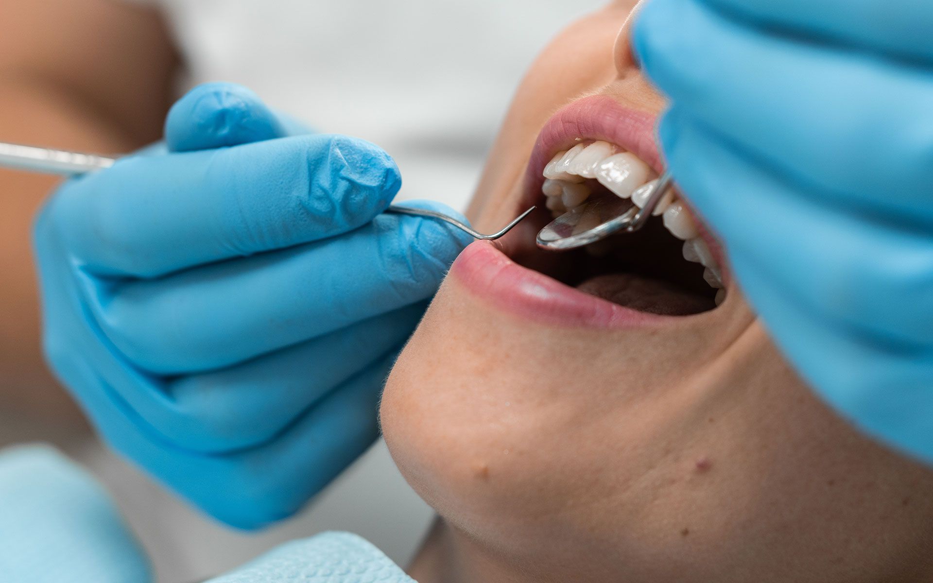 A woman is getting her teeth examined by a dentist.
