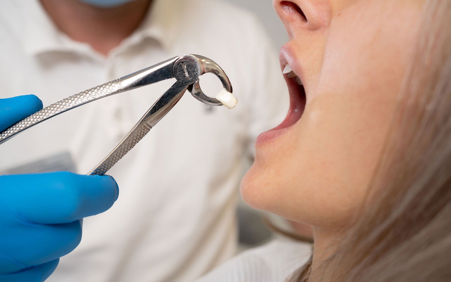 A woman is getting her teeth removed by a dentist.