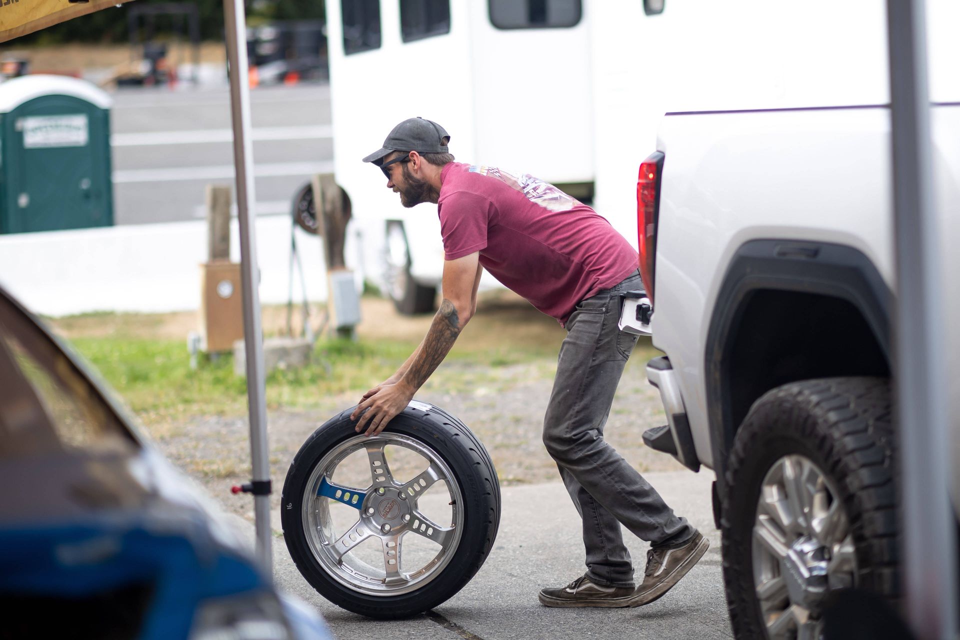 A man is changing a tire on a race car.