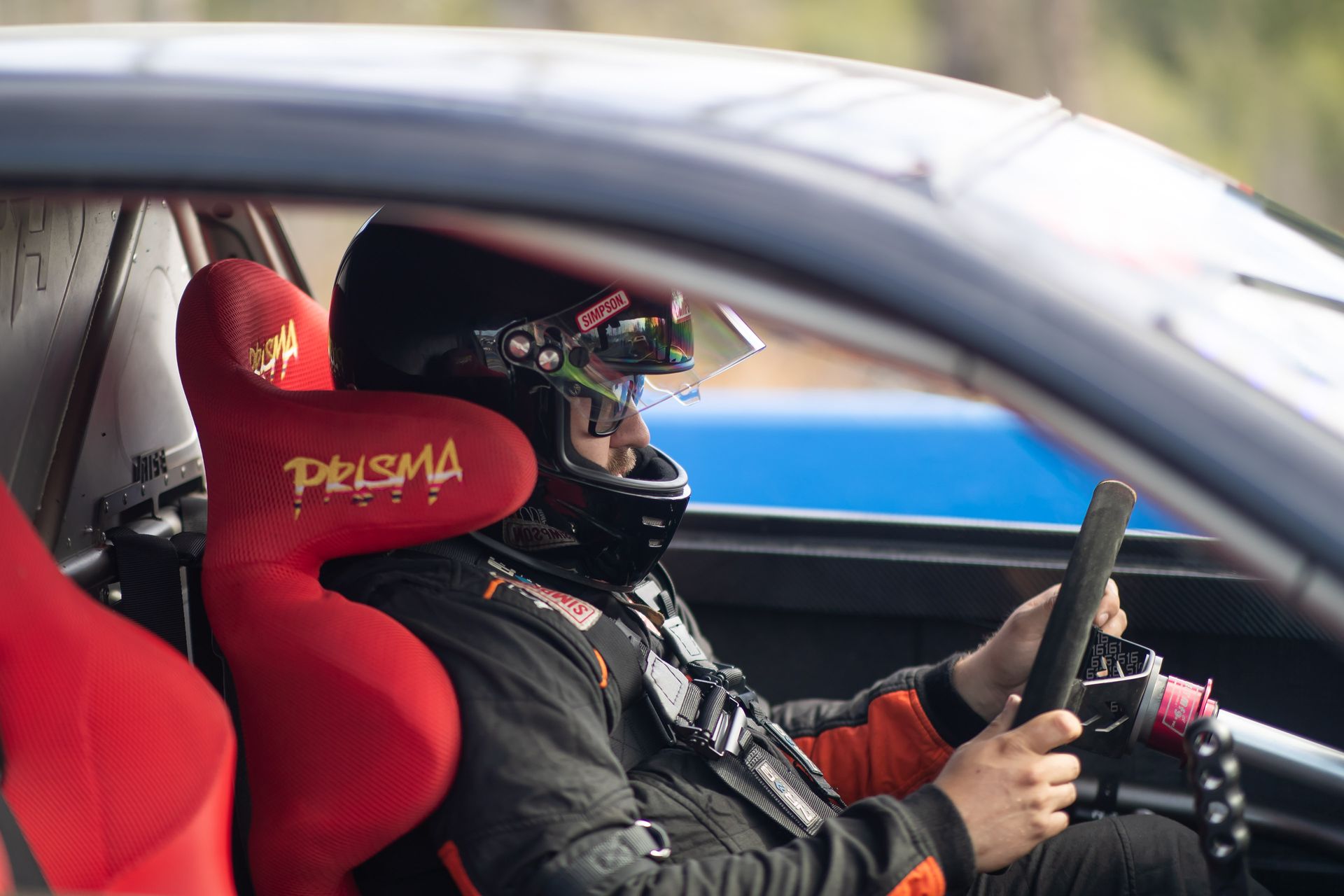 A man wearing a helmet is driving a race car.
