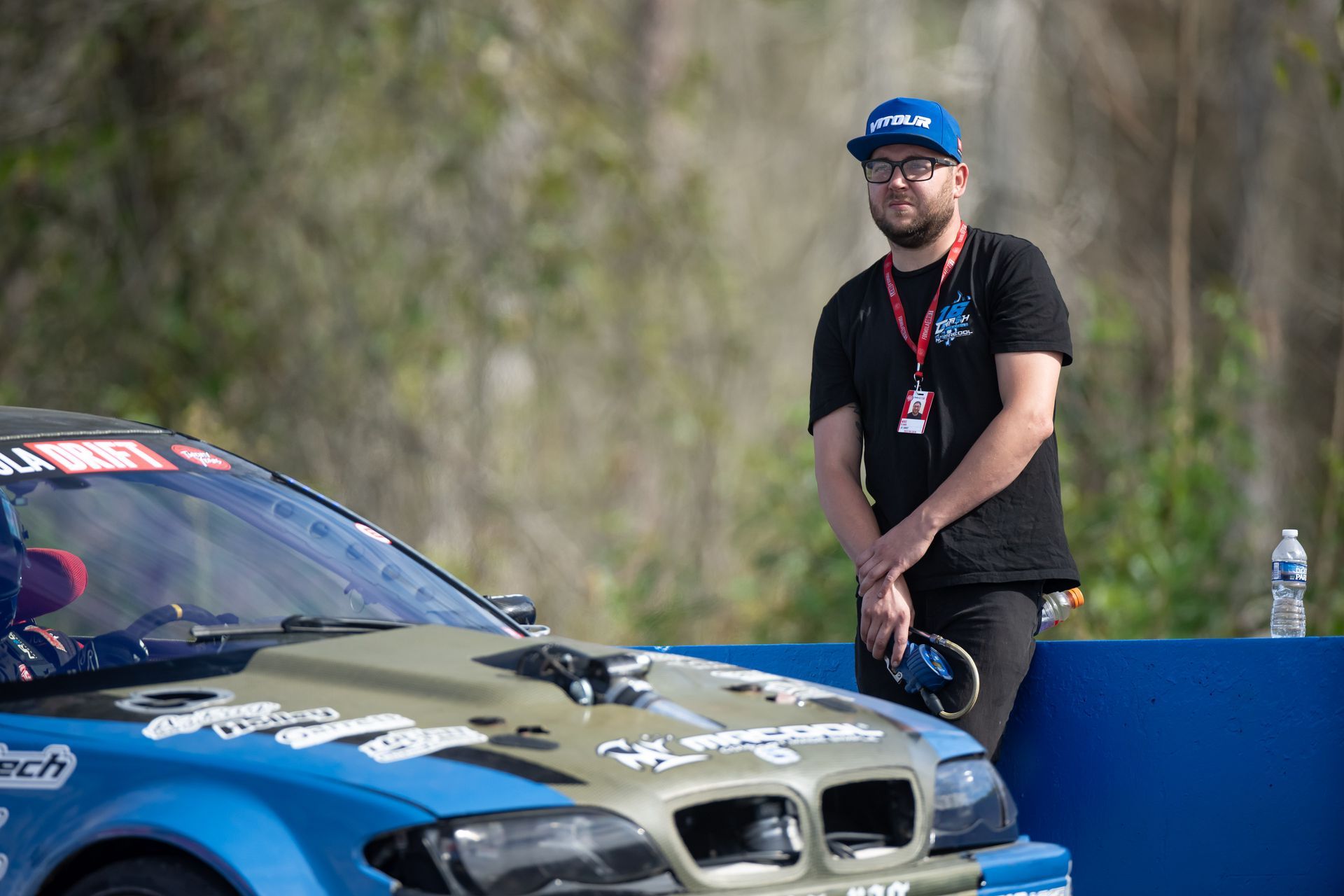 Mike Klamm is leaning on the hood of a race car.