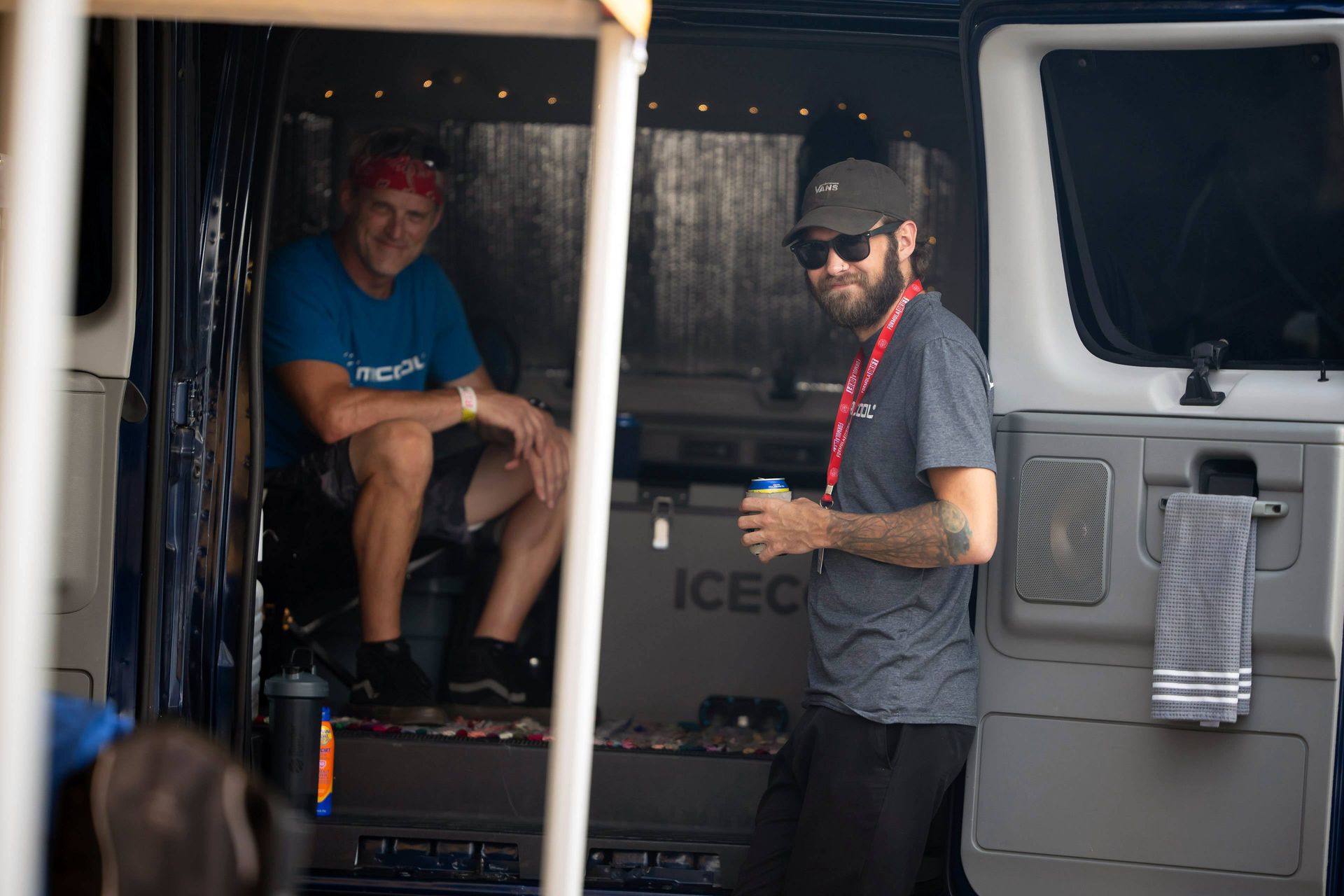 Glen Arterburn wearing a blue shirt that says mcool sits in a van next to Cameron Chapman standing