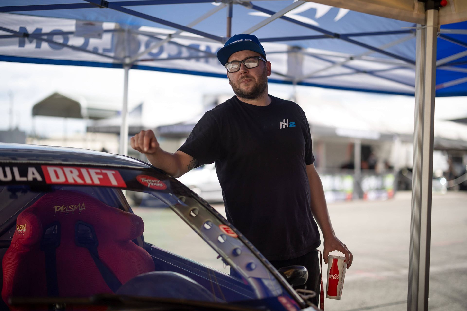 Mike Klamm is standing next to a car under a tent.