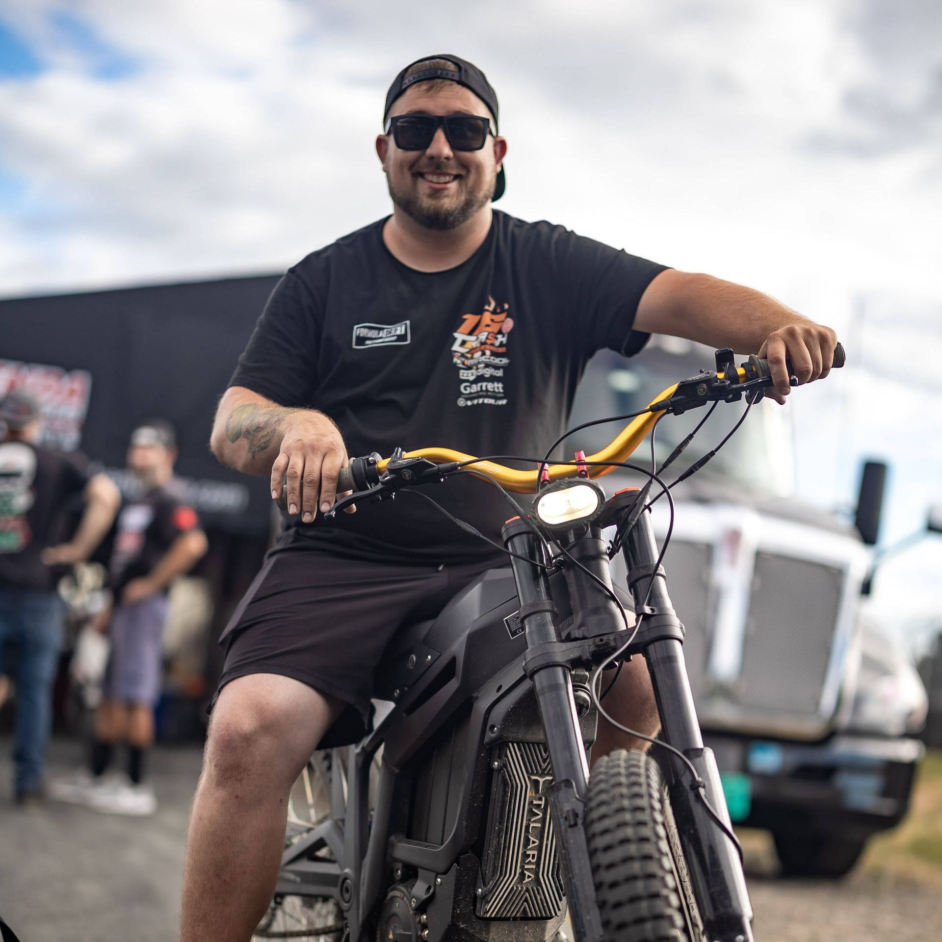 A man wearing sunglasses is sitting on a motorcycle
