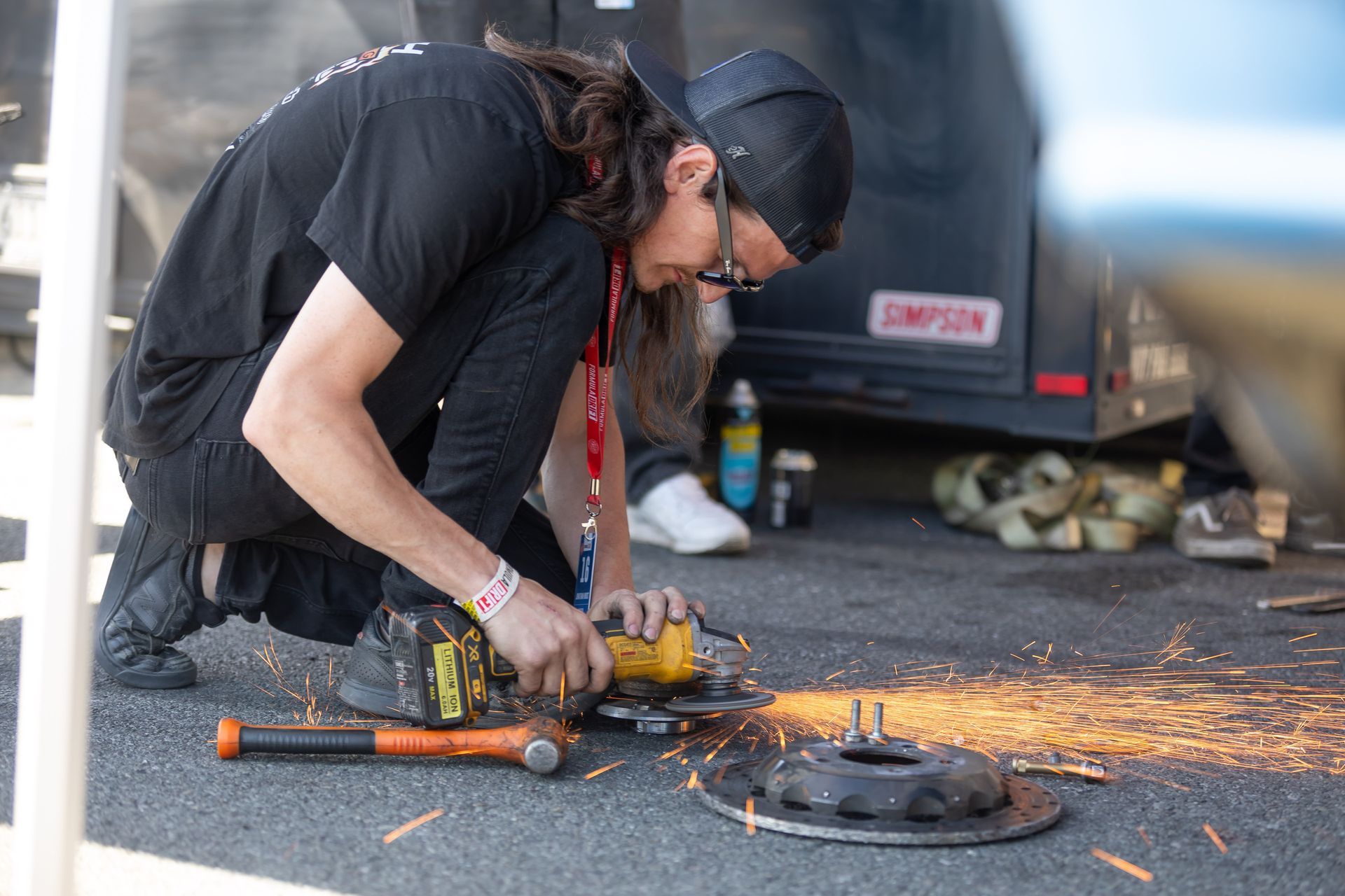 A man is using a grinder to cut a piece of metal.