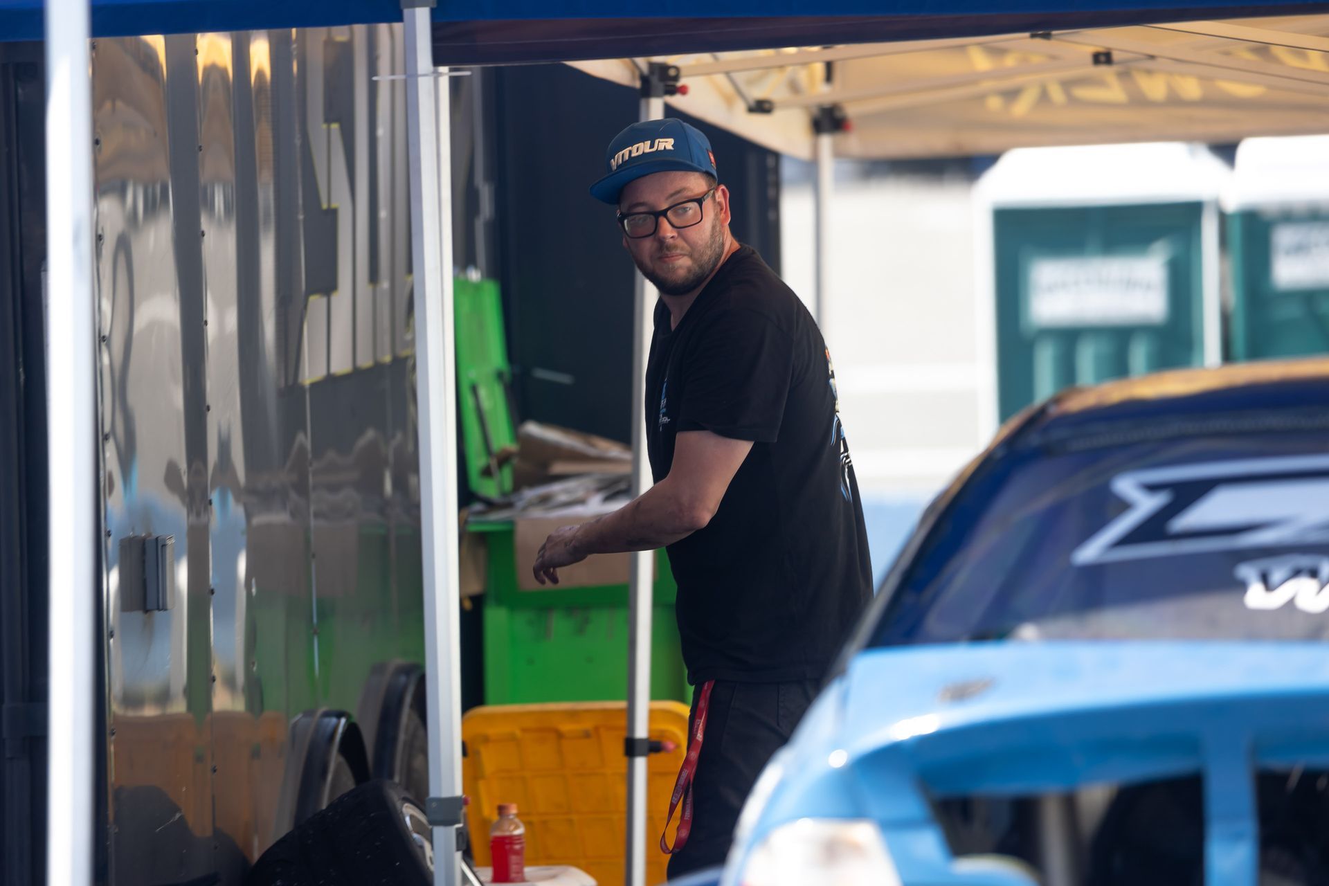 Mike Klamm is standing under a tent next to a car.