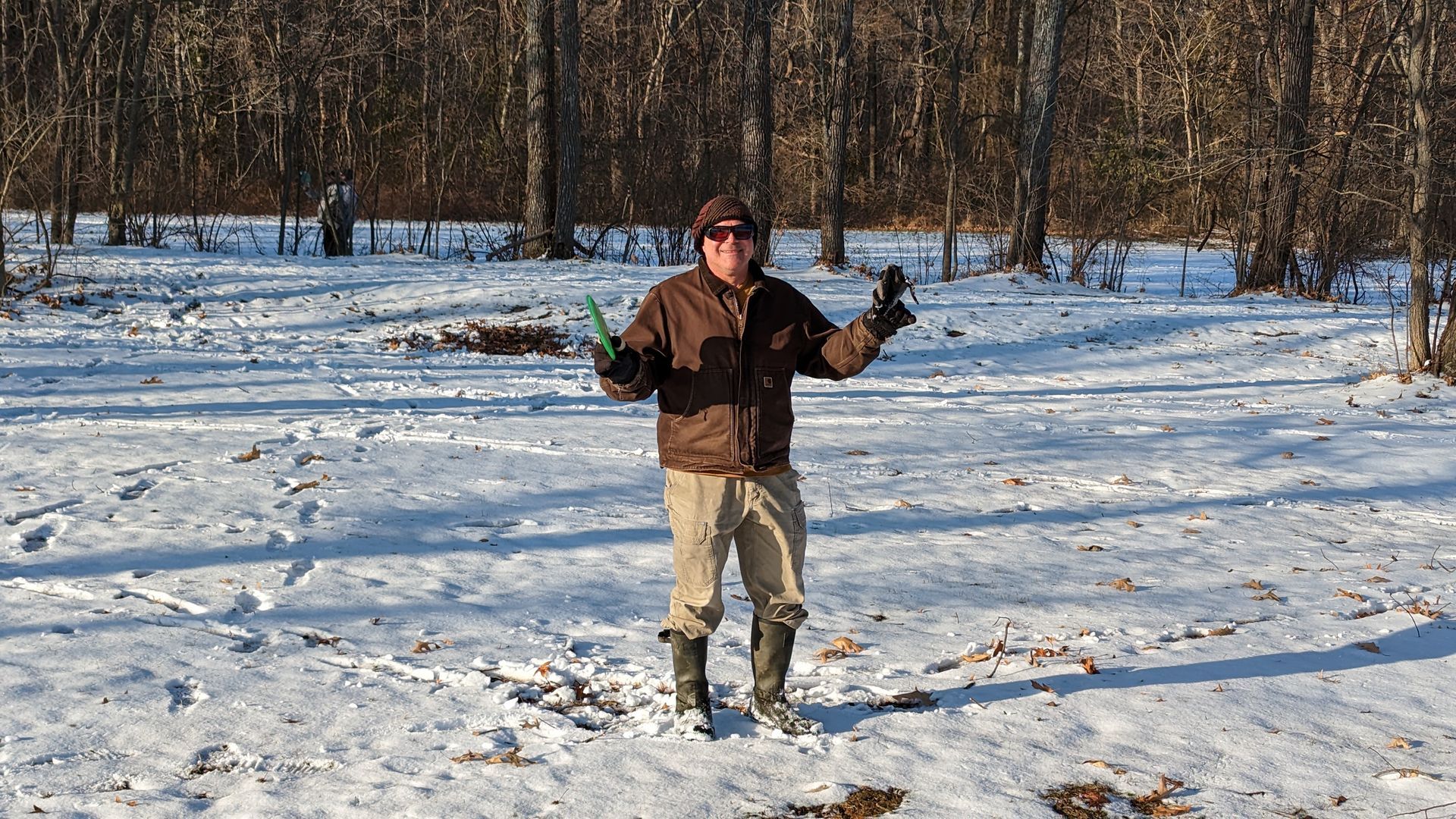 A man is standing in the snow with his arms outstretched