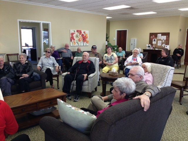 Group of people seated in a room, watching a performance.