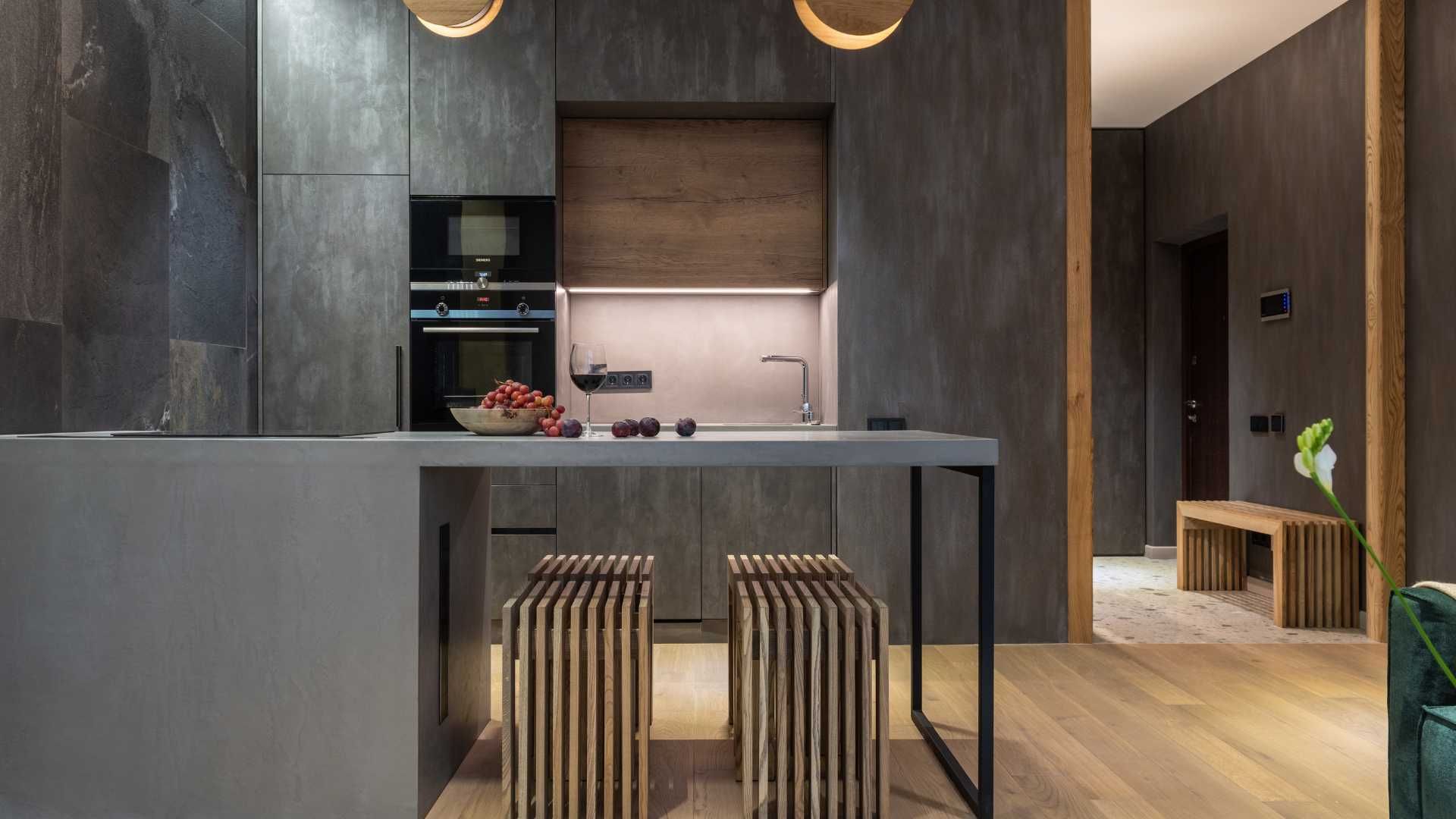 A kitchen with a table and stools in it.