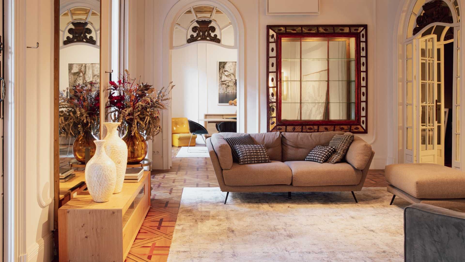 A living room with a couch and a mirror on the wall