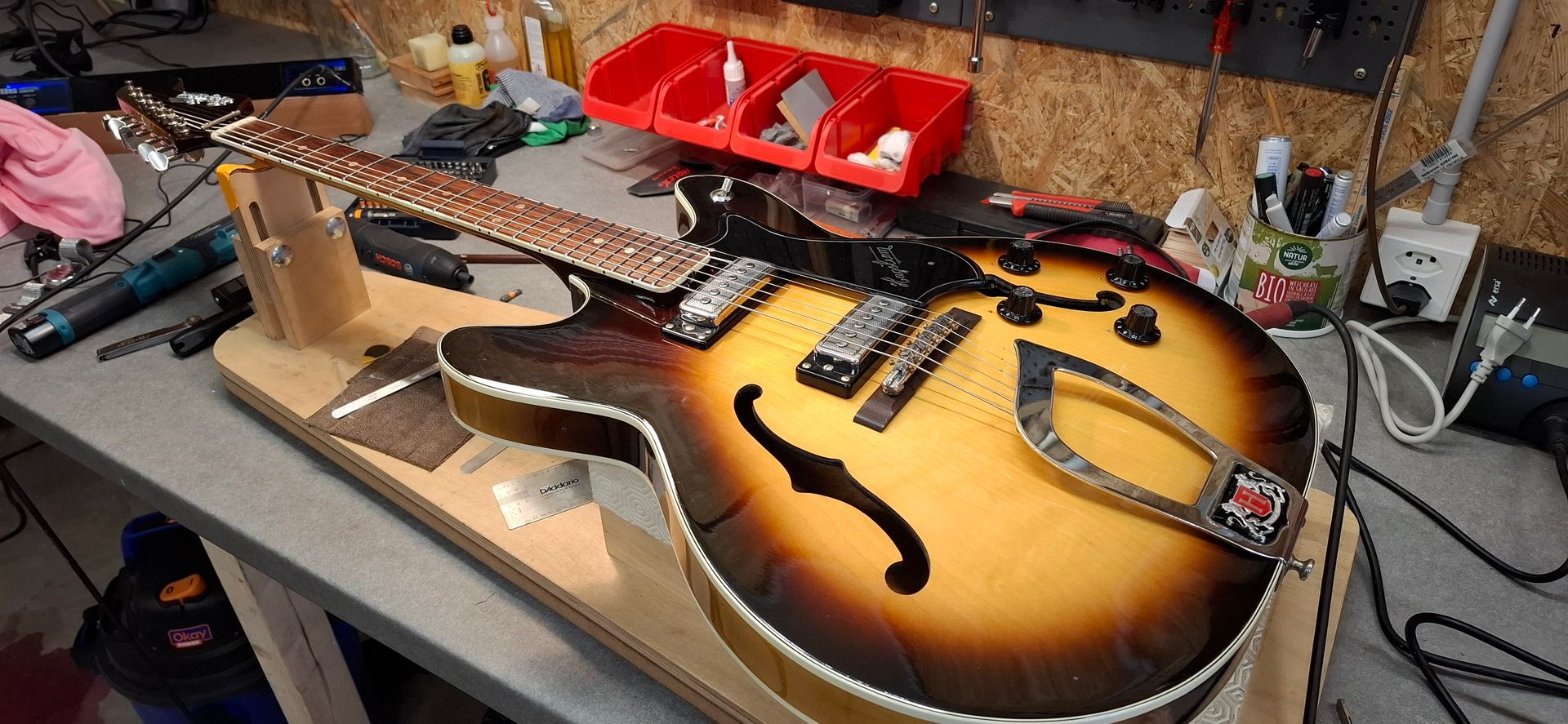 Guitare posé sur un établi en cours de réglage.