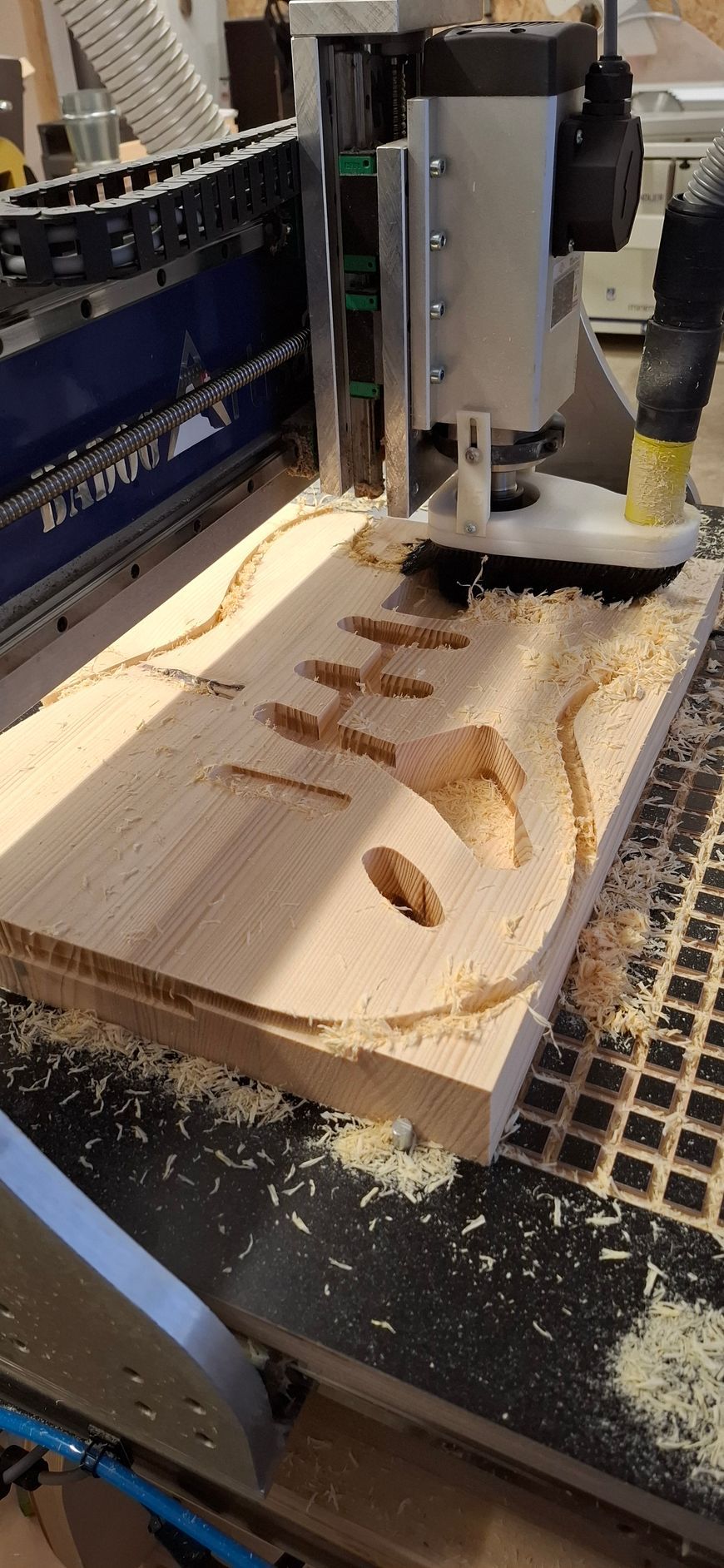 Corps de guitare éléctrique en cours de fraisage sur une CNC