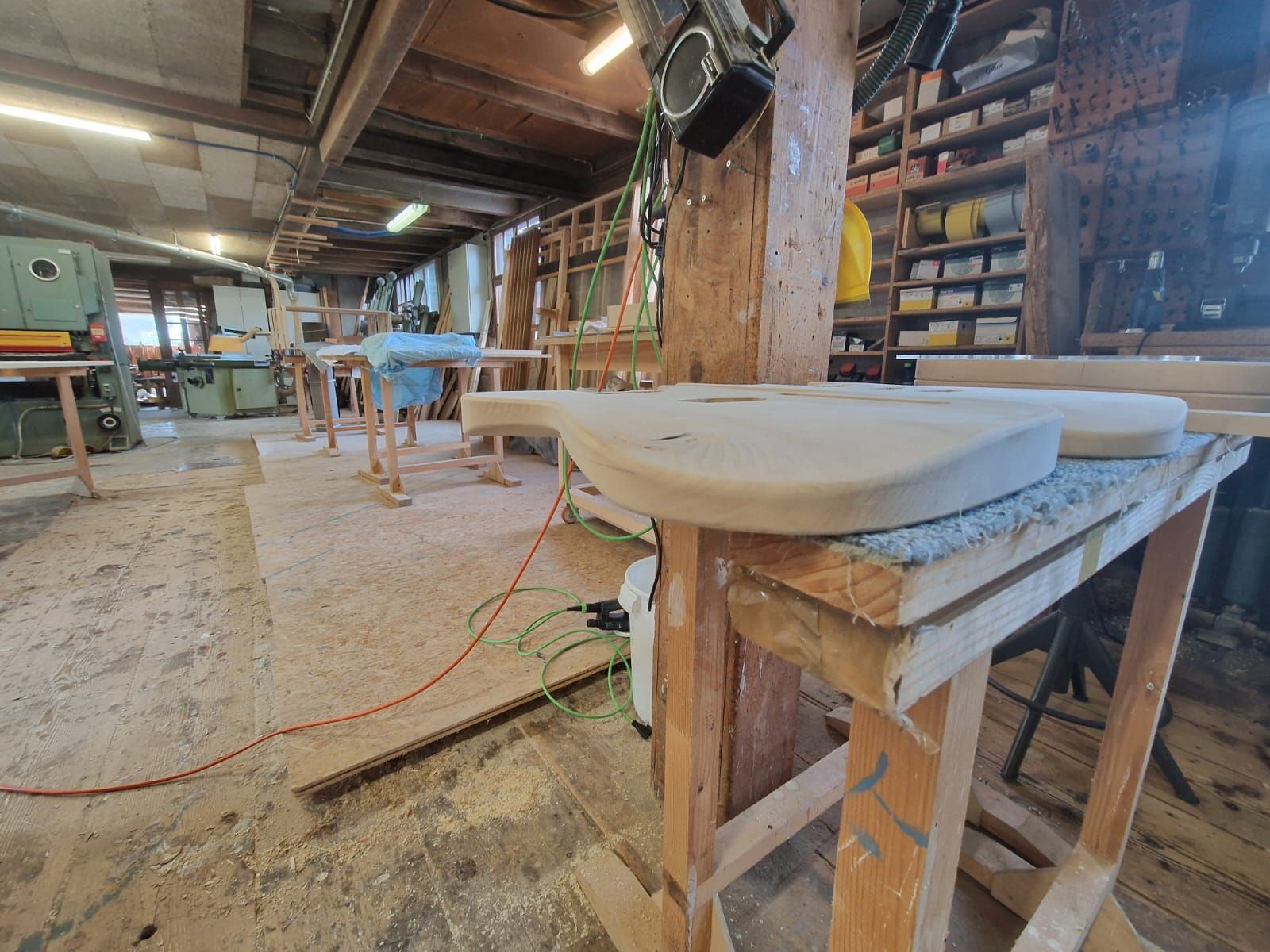 Un morceau de bois est posé sur une table en bois dans un atelier.