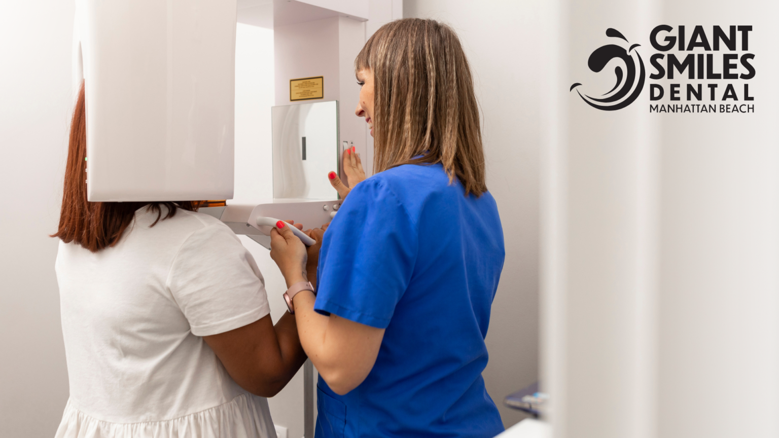 Two women are standing next to each other in a dental office looking at a shelf.