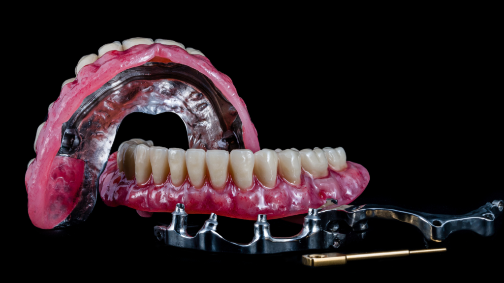 A close up of a denture on a black background.