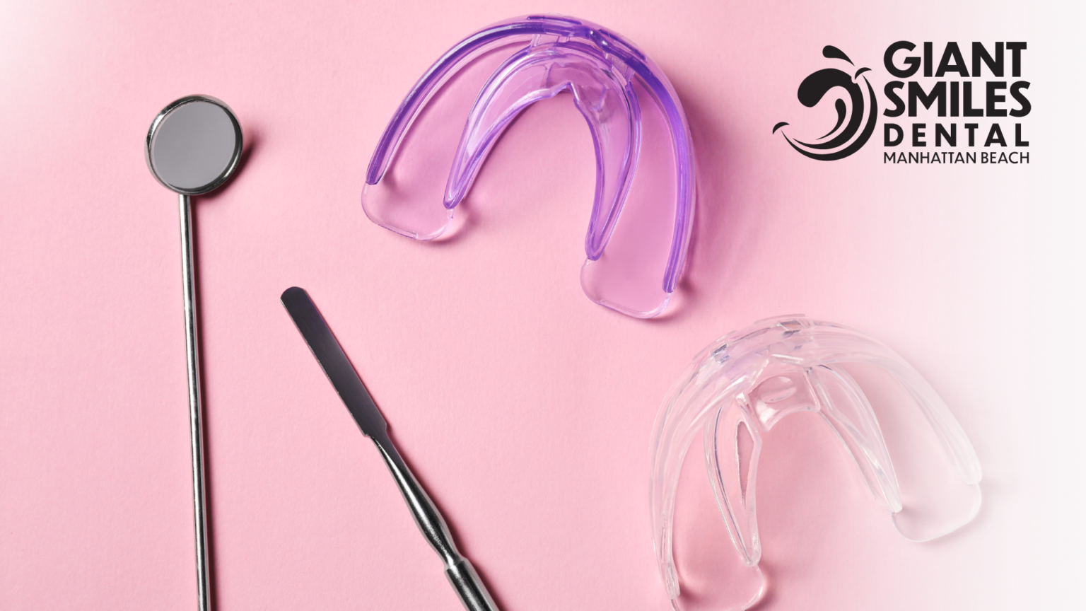 A pair of mouth guards , a dental mirror , and a spatula on a pink surface.