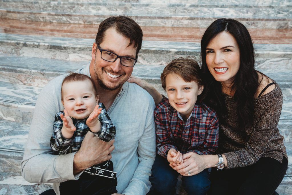 A family is posing for a picture on a set of stairs.