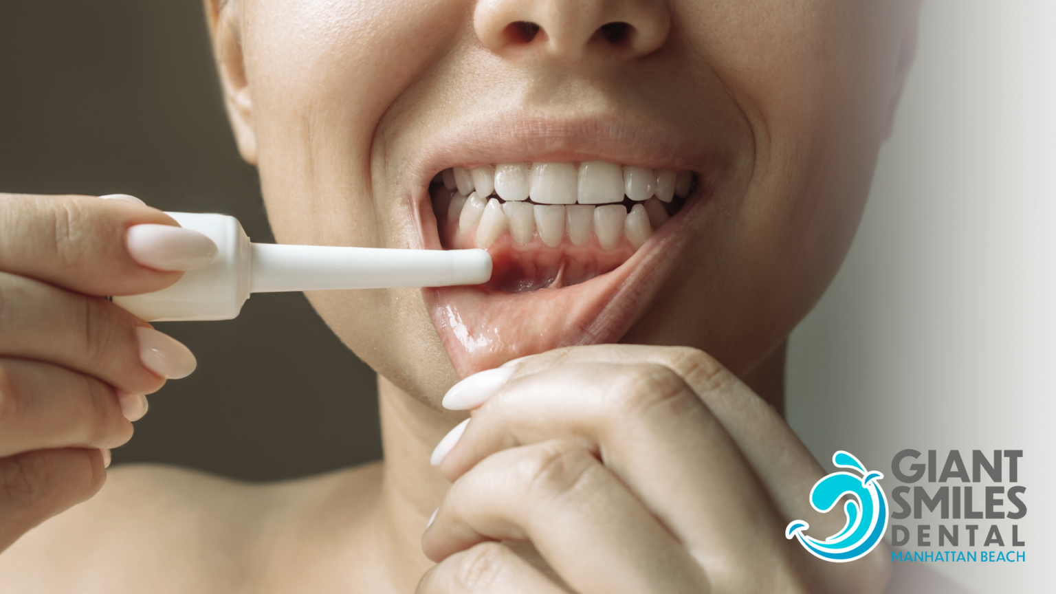 A woman is brushing her teeth with a toothbrush.