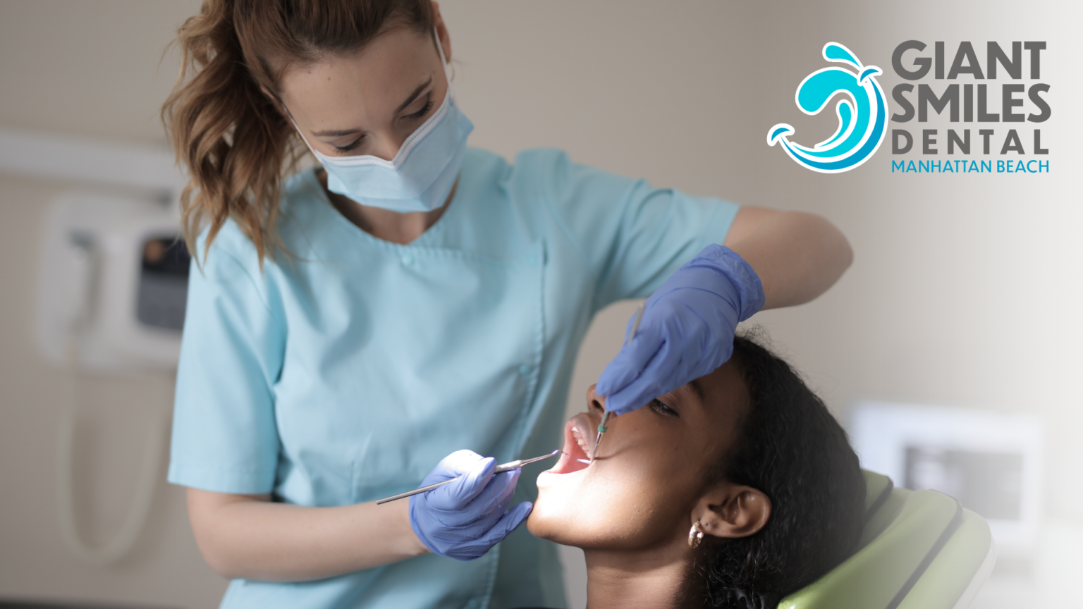 A dentist is examining a woman 's teeth in a dental chair.